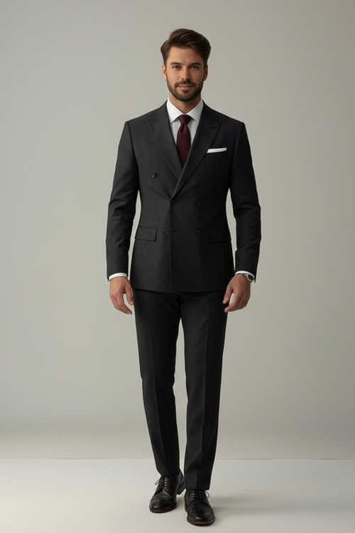 Man wearing a black suit with a red tie against a plain background