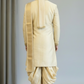 Man wearing a traditional cream-colored sherwani with a turban against a plain background