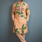 Man wearing a floral kurta with beige pants against a gray background