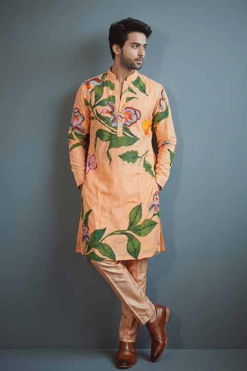 Man wearing a floral kurta with beige pants against a gray background