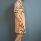 Man wearing a peach kurta with floral patterns against a gray background