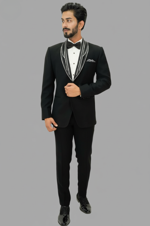 Man wearing a black tuxedo with white trim on a gray background