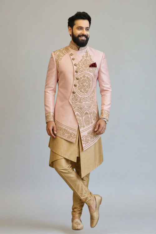 Man wearing a traditional embroidered sherwani against a plain background