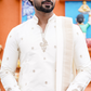 Man wearing a white embroidered kurta with a colorful background