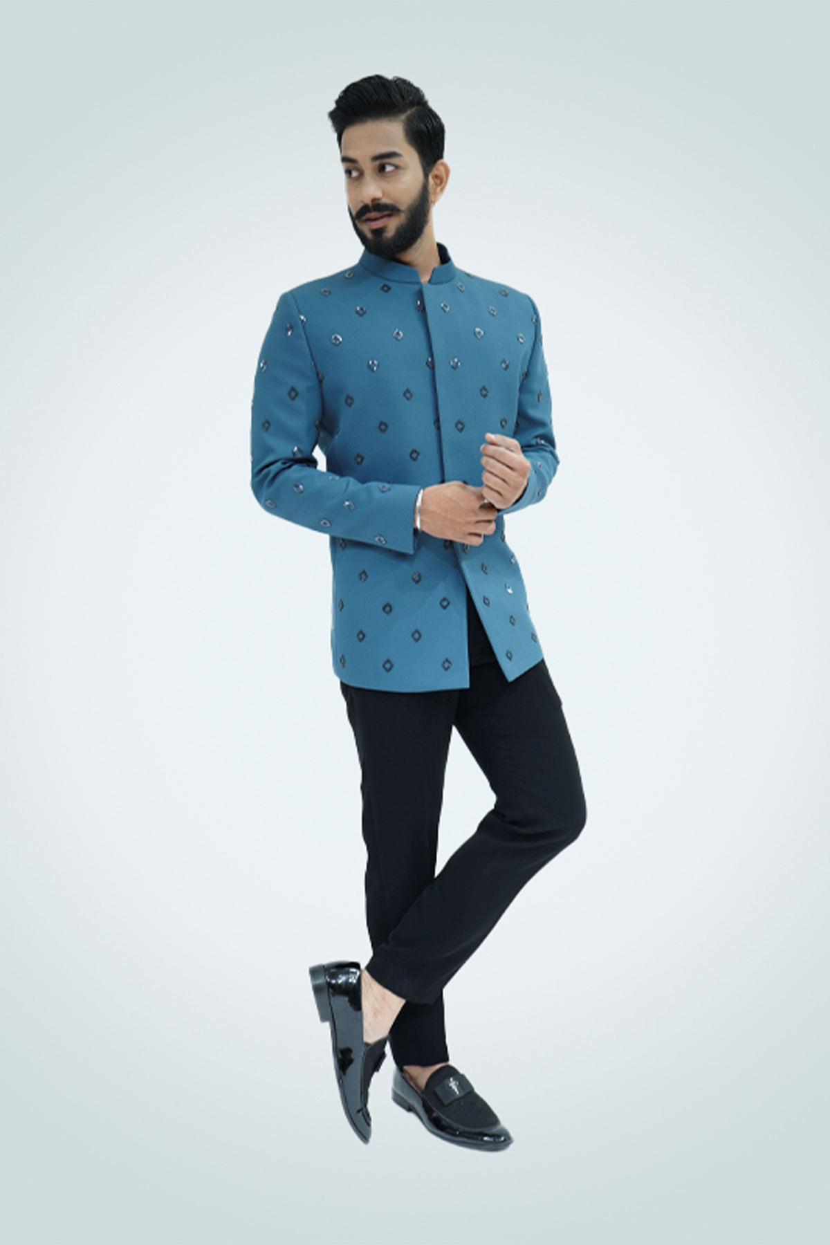 A man wearing an ash blue metallic cut dana embroidered jodhpuri with a collared neckline and button details.