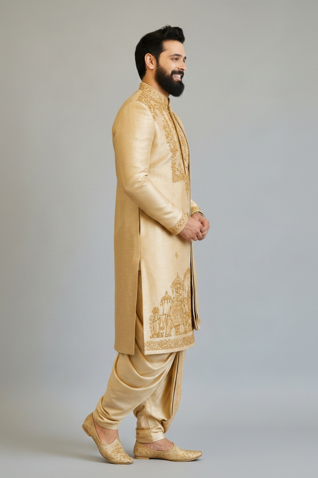 Man wearing a traditional beige sherwani with intricate embroidery on a plain background