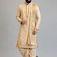 Man wearing a traditional beige kurta with embroidery on a plain background