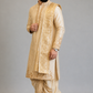 Man wearing a traditional beige kurta with white dhoti on a gray background
