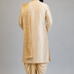 Man wearing a traditional beige kurta with dhoti on a plain background