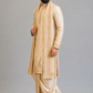 Man wearing a beige embroidered sherwani on a gray background
