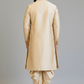 Man wearing a beige sherwani with dhoti on a plain background