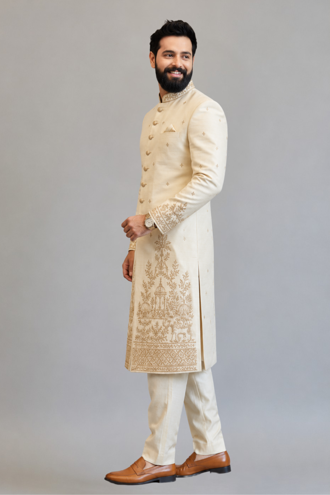 Man wearing a cream embroidered sherwani against a gray background