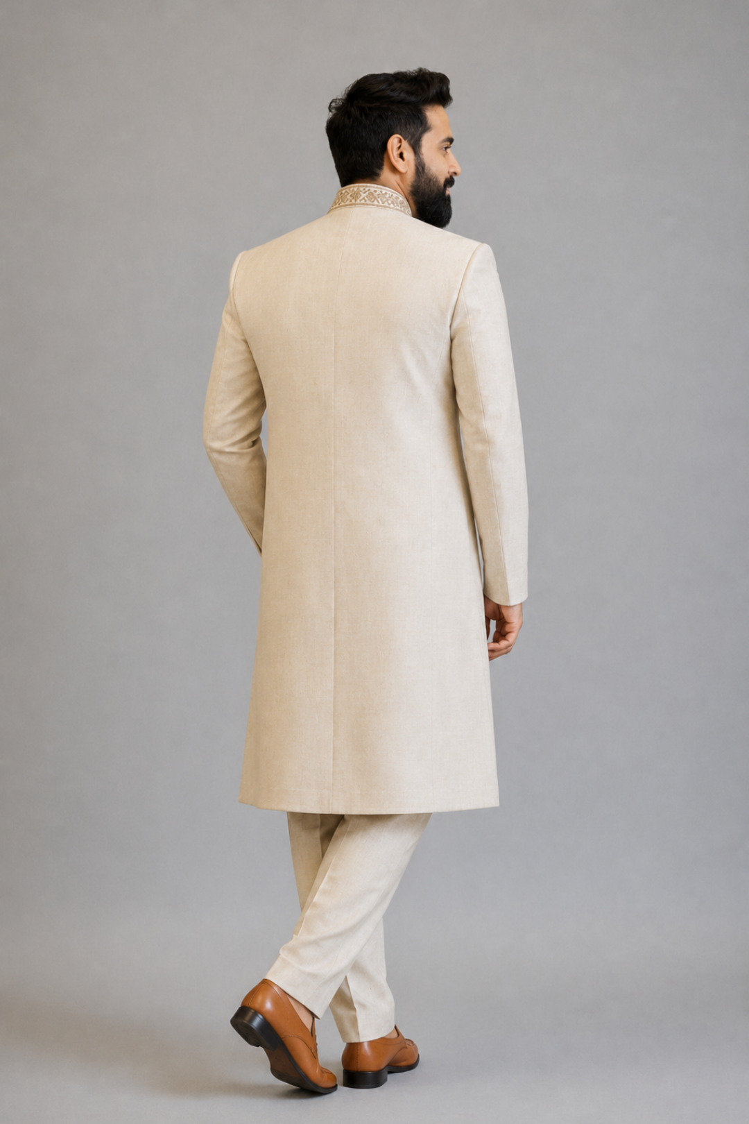 Man wearing a beige traditional outfit on a gray background