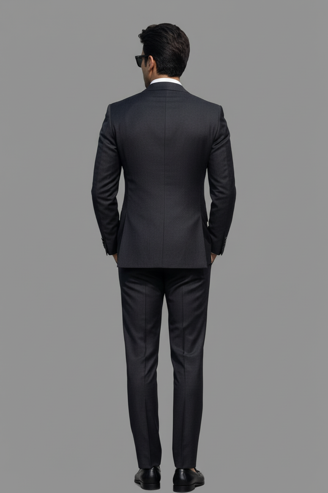 Man wearing a black suit on a gray background