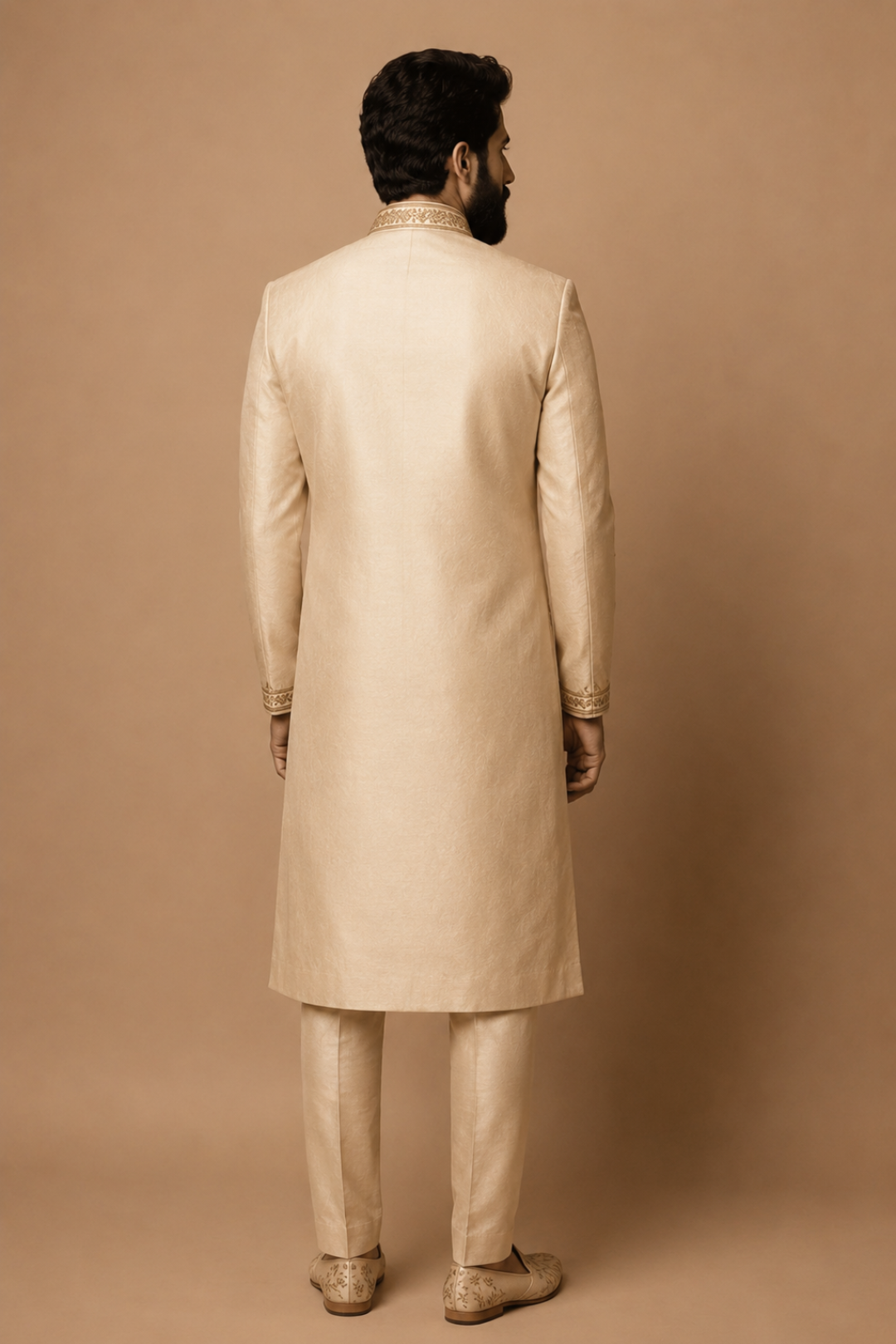 Man wearing a beige sherwani against a brown background