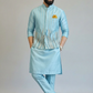 Man wearing a light blue traditional outfit with a plain background