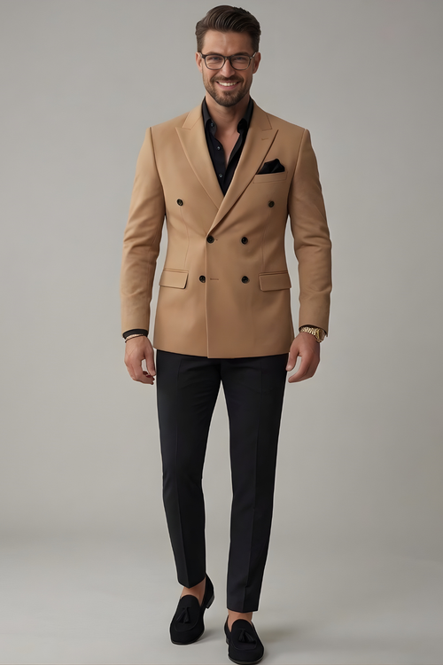 Man wearing a beige blazer, black shirt, and black pants on a gray background