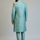 Man wearing a light blue sherwani with a plain background