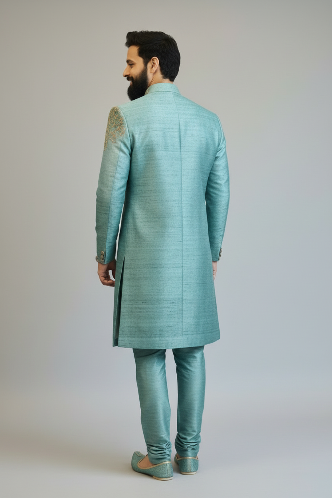 Man wearing a light blue sherwani with a plain background