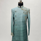 Teal sherwani on a mannequin with intricate embroidery against a light gray background