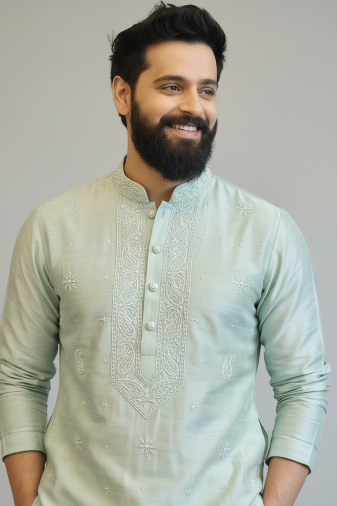 Man wearing a light green embroidered kurta against a plain background
