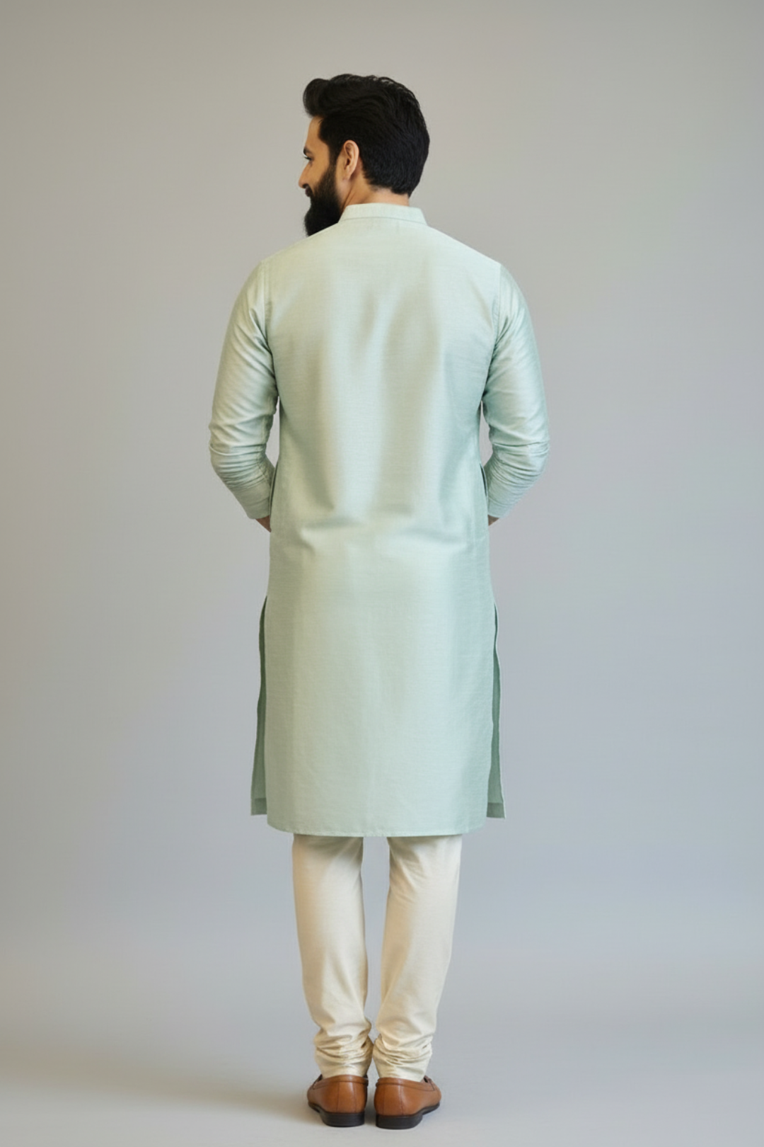 Man wearing a light green kurta with white pants on a plain background