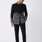 Man wearing a black embroidered jacket and pants on a white background
