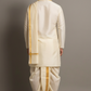 Man wearing a traditional white dhoti with gold accents against a gray background