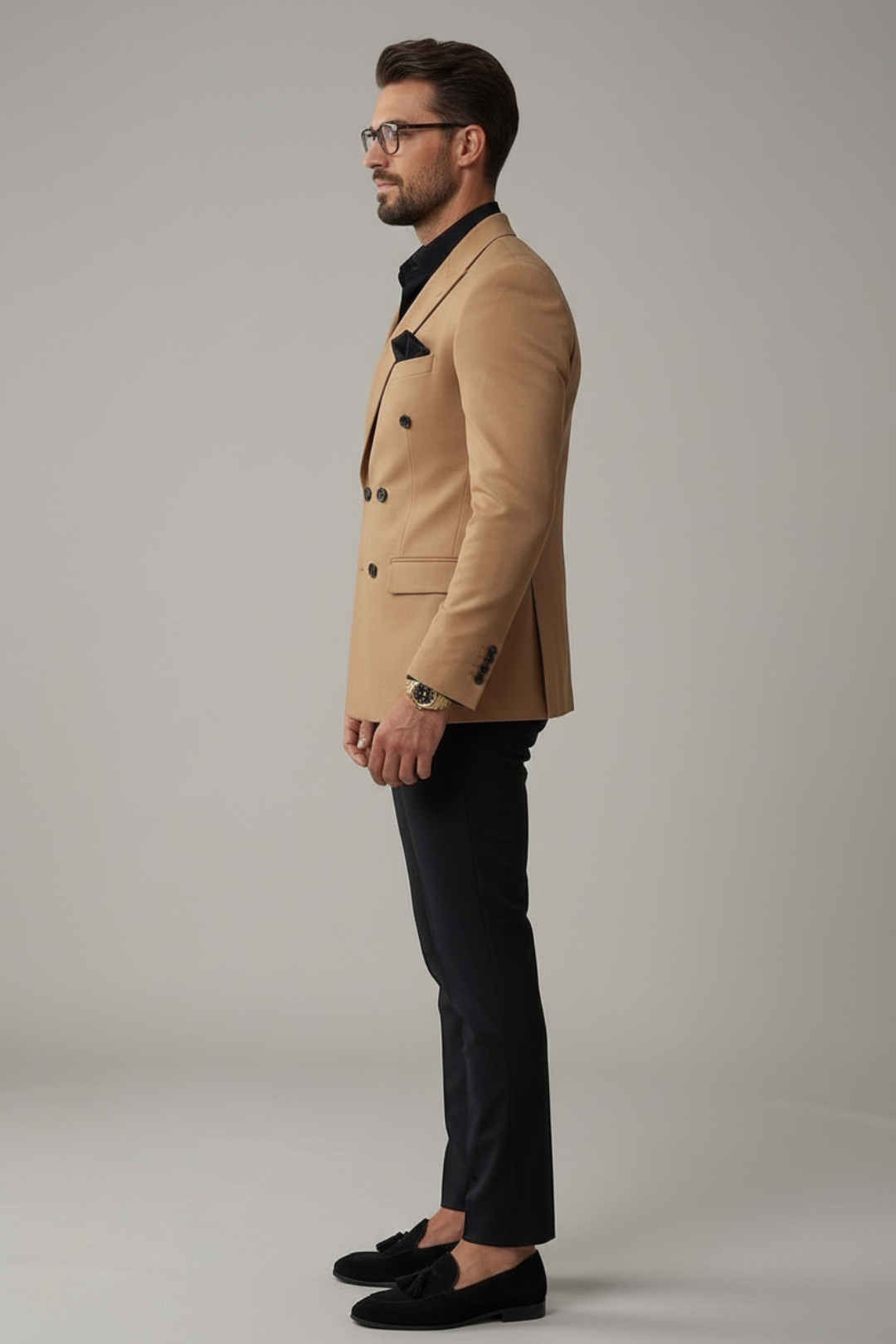 Man wearing a beige blazer and black pants on a gray background