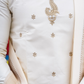 Close-up of a white embroidered garment with intricate designs.