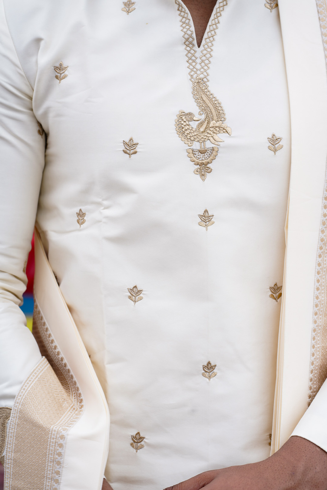 Close-up of a white embroidered garment with intricate designs.