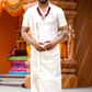 Man in traditional white attire standing in front of a temple structure