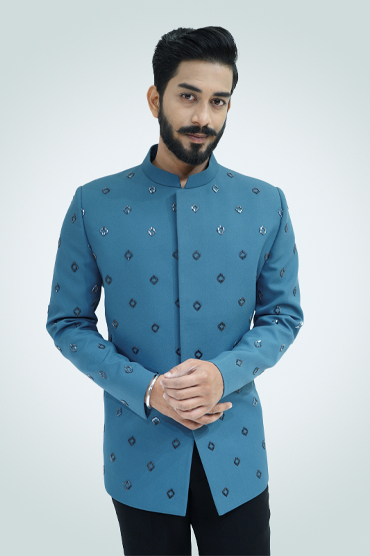A man wearing an ash blue metallic cut dana embroidered jodhpuri with a collared neckline and button details.