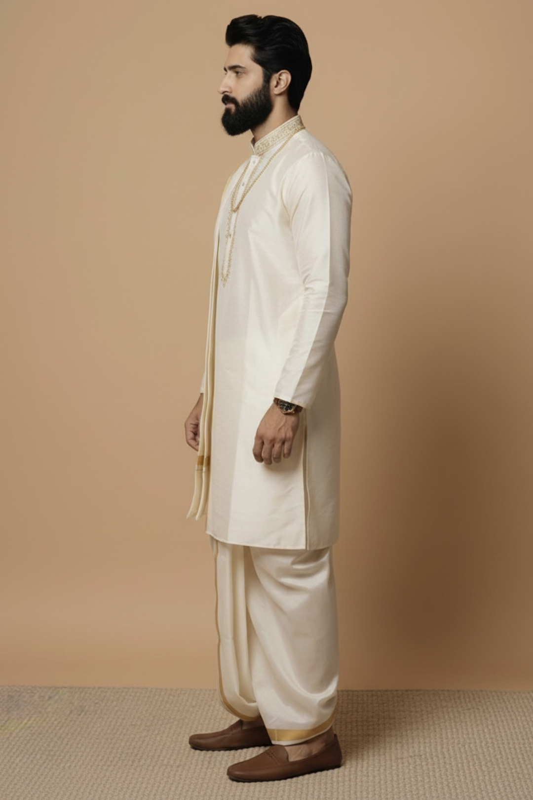 Man wearing a traditional cream kurta with brown shoes against a beige background