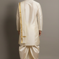 Man wearing a traditional cream kurta with gold accents against a gray background
