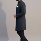 Man wearing a dark blue kurta with black pants against a plain background