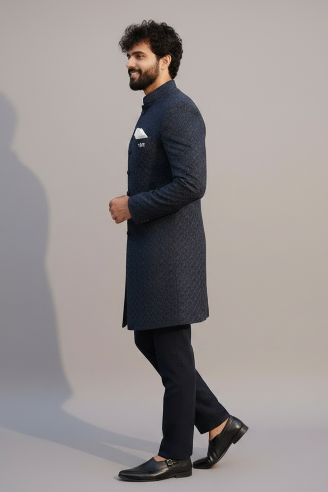 Man wearing a dark blue kurta with black pants against a plain background