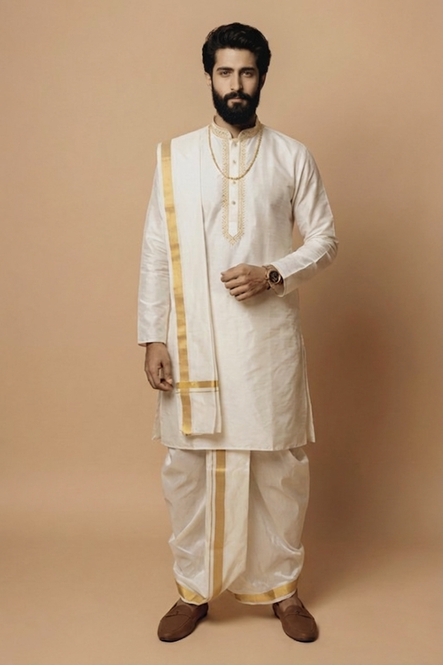 Man wearing a traditional white kurta with gold accents on a beige background