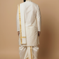 Man wearing a traditional white kurta with gold accents on a beige background