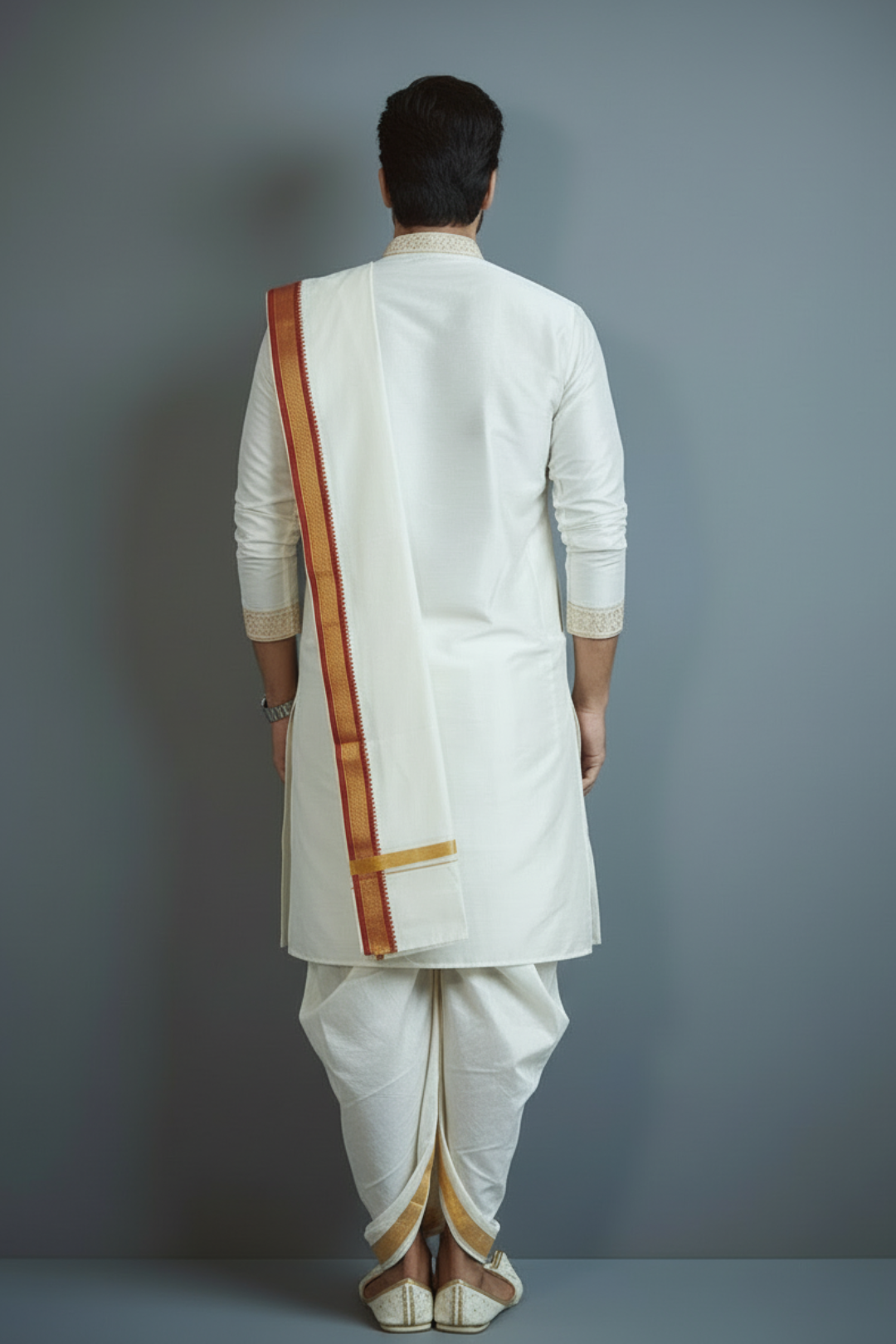 Person wearing a traditional white kurta with a red and gold border against a gray background