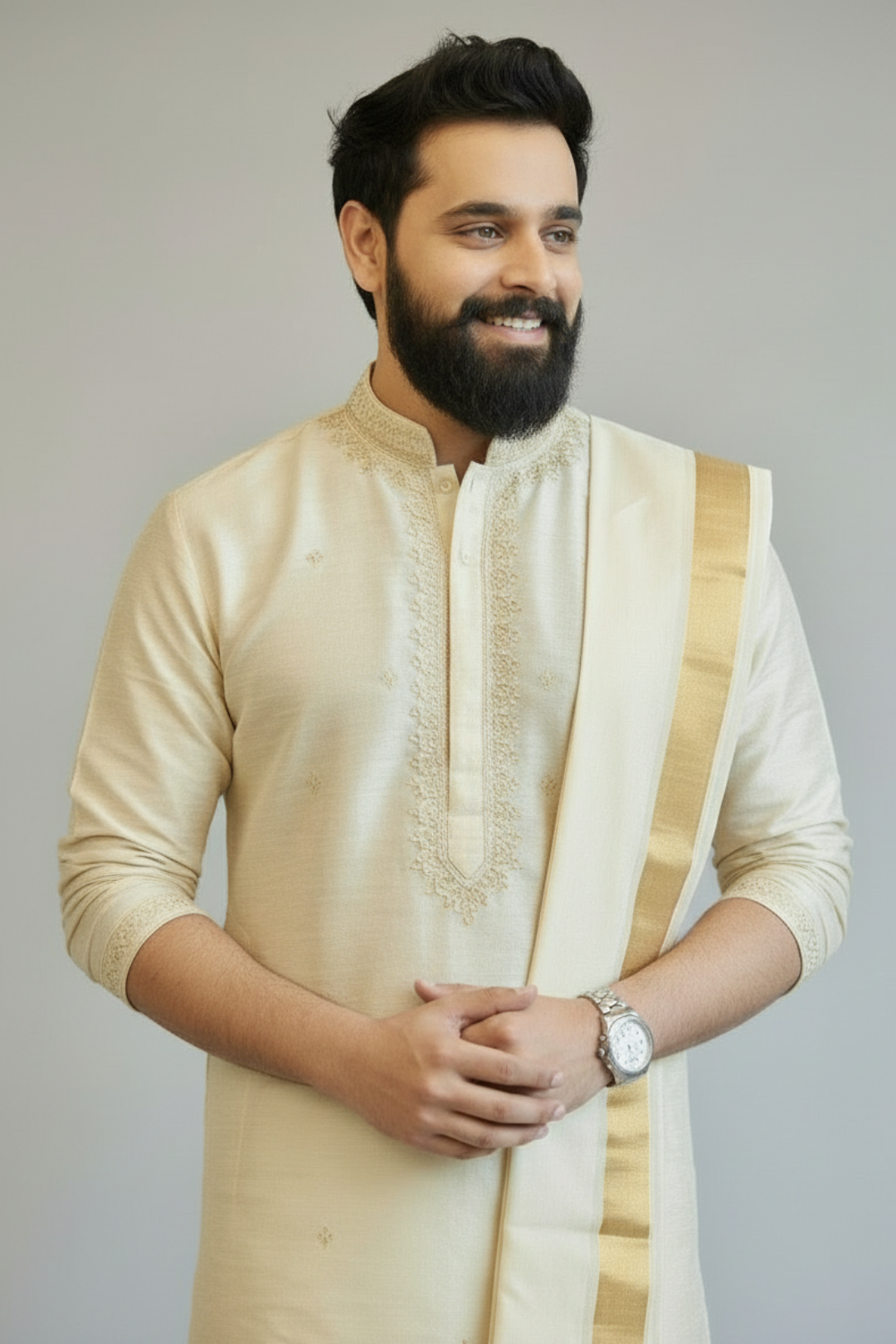 Man wearing a cream kurta with a gold border against a plain background