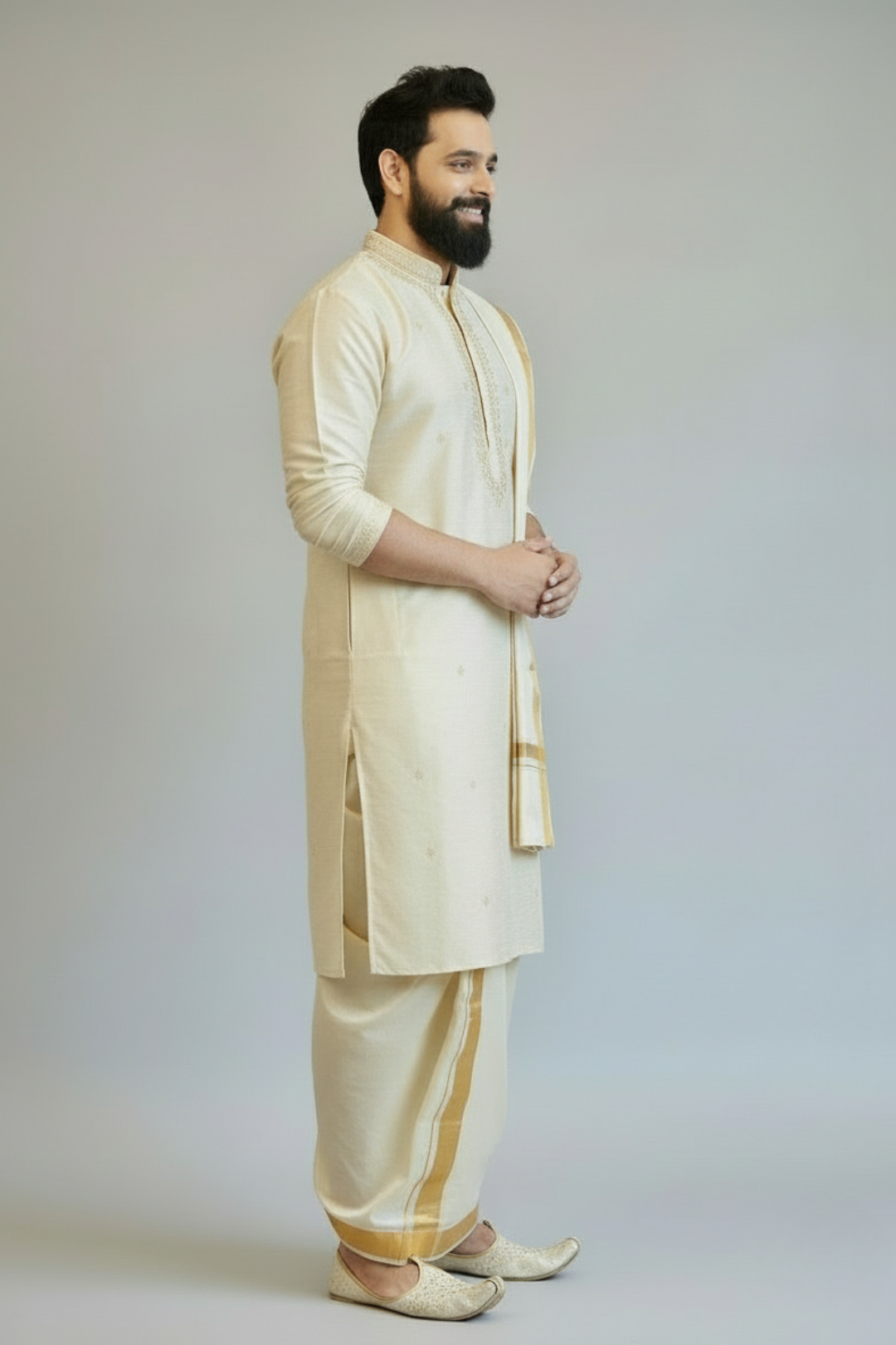 Man wearing a cream kurta with gold accents on a plain background