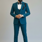 Man wearing a teal suit with a white shirt and brown shoes on a plain background