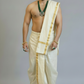 Man wearing a traditional white dhoti with gold borders on a plain background