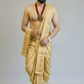 Man wearing a traditional gold dhoti with jewelry on a plain background