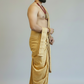 Man wearing a yellow dhoti against a plain background