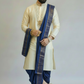 Man wearing a traditional outfit with a blue dhoti and beige kurta on a plain background