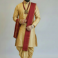 Man wearing a traditional beige kurta with a red shawl on a plain background