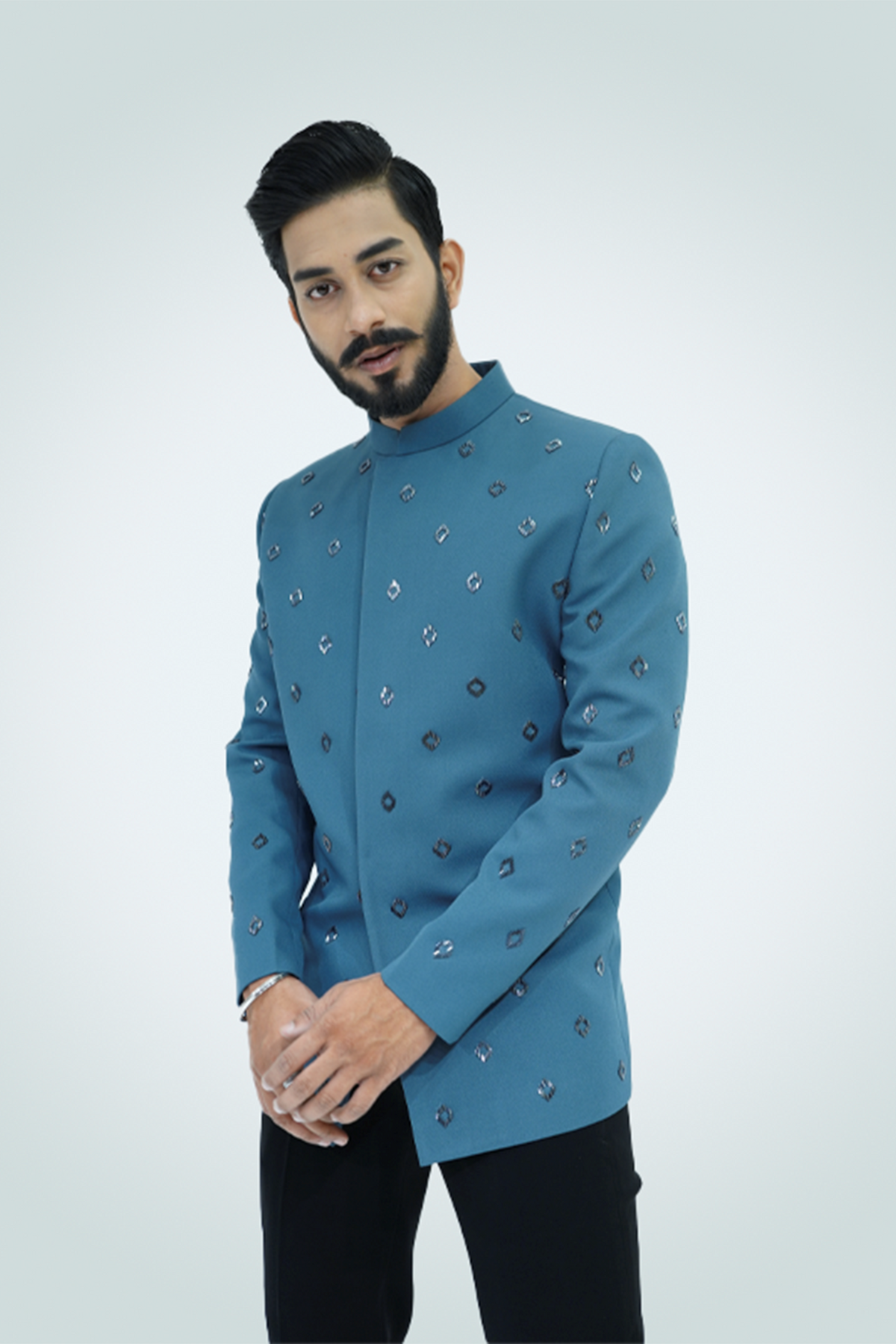 A man wearing an ash blue metallic cut dana embroidered jodhpuri with a collared neckline and button details.