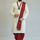 Man wearing a traditional white kurta with a red dhoti on a plain background